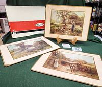 Three Pimpernel wood-backed placemats laid flat with original box, showing all three placemats and the box with red and black logo.
