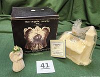 Box for Angelic Carole candle with unwrapped Santa Lucia figurine and wrapped Homestead church candle