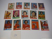 Lot of 15 hockey cards arranged on a white surface showing players from teams such as North Stars, Flames, Kings, Canucks, Red Wings, Flyers, Canadiens.