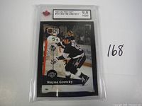 Front photo of 1991-92 Wayne Gretzky Pro Set hockey card #101 in protective case showing player near goal in Los Angeles Kings uniform. Card graded 9.5 by NGM.