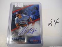 Front view of 2021 Topps Certified Alex Manoah rookie baseball card in protective sleeve, showing autograph and player image.