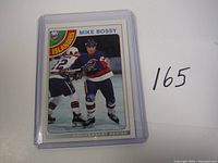 Front of Mike Bossy hockey card in protective holder with visible player image and New York Islanders logo.