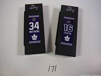 Front view of two mini hockey sticks side by side showing player names and numbers with Tim Hortons branding.