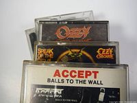 Close-up of the cassette tape cases showing Ozzy Osbourne, Accept albums