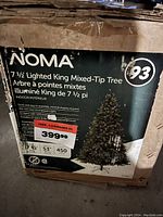 Original box for 7.5 ft NOMA Lighted King Mixed-Tip tree with product details including light count, branch tips, and price sticker.