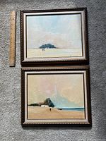 Both framed oil paintings side by side with ruler for scale.