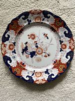 Front view of the antique Ironstone small plate with multicolor floral design and scalloped edge