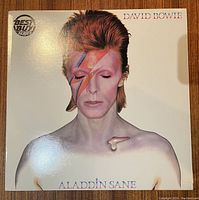 Front cover of David Bowie's Aladdin Sane album showing iconic lightning bolt makeup.