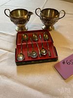 Creamer, sugar bowl and six teaspoons displayed, showing overall set and condition.