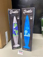 Photo of two boxed Jambo lava lamps side by side, one with green wax in clear liquid, one with white wax in blue liquid