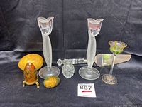 Full view of large yellow marble egg, lacquer eggs, cut crystal egg, frosted glass candlesticks, and green stemmed glass.