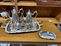 Full view of the silver plated tea set arranged on the tray with the butter dish placed separately on the table.