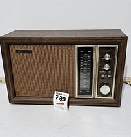 Full front view of Sony TFM-9450W radio showing wood finish case, speaker grille with fabric, and control panel with tuning scale and knobs.