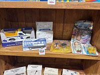 Shelf display including toy trucks banks, boxed model cars, and assorted figures