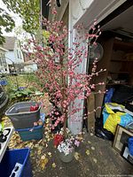 Full view of the faux cherry blossom tree with pink artificial flowers in a grey pot, showing the tree's height and detail of blossoms.