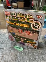 Photo of the Green Magic Hose box showing branding, features, length (50 ft / 15 m), and 'The Hose That Grows' claim.
