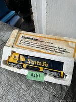 Vintage Bachmann Santa Fe locomotove in blue and yellow paint sitting in its original white foam packaging, showing product information on packaging and the model locomotive with number 4301.