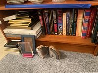 Shelf with hardcover books, photo frames, and two natural stone bookends