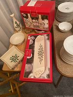 Lenox Holiday collection displayed on table including napkin holder, vase, bowl, plates and boxed serving trays