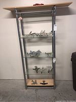 Full display stand with 10 model airplanes arranged on four glass shelves showing different aircraft models.
