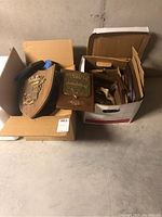 Two open boxes seen from above showing various plaques in an unorganized pile.