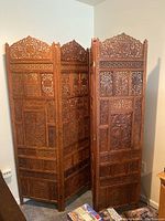 Full view of the three-panel folding screen showing intricate carvings and folded position.