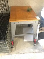 View of the entire work table showing wood top and metal frame with wheels.