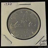 Reverse side of the 1966 Canadian silver 1 dollar coin showing the voyageur canoe design with the year 1966 and denomination.