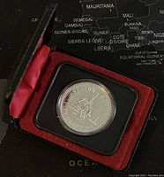 Photo showing the silver coin inside a protective case with a red velvet interior.