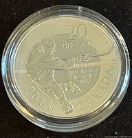 Obverse of the silver coin featuring hockey player and denomination details.