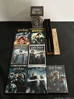 Full display of all items: 7 DVDs, wand in box with Diagon Alley design, and Dobby figurine in clear box.