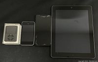 Front view of iPod Classic, iPod Touch, iPhone 11, iPad on black surface