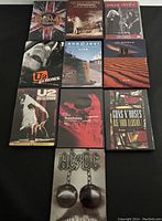10 rock band DVD videos with cover art including Aerosmith, Queen, Thin Lizzy, U2, Bon Jovi, Led Zeppelin, Bryan Adams, Guns N' Roses, and AC/DC.