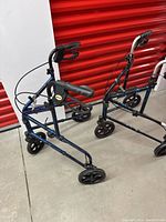 Two Drive collapsible support walkers side by side showing frame design, handlebars, and wheels.