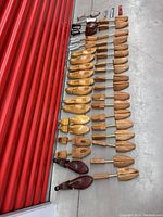 Entire collection of wooden shoe forms, various colors and sizes, arranged neatly on floor