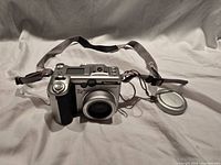 Canon PowerShot G6 camera angled front with strap and lens cap visible