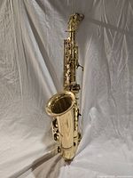 Full view of brass alto saxophone standing upright