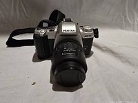 Front view of Pentax MZ-50 with lens, cap and strap visible