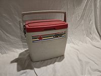 Front view showing decal, red lid, white body, handle up