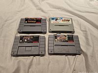 Four SNES cartridges arranged on fabric