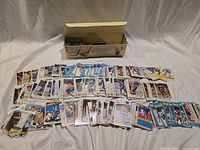 Overview with storage box and spread of hundreds of hockey and baseball cards