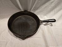 Top view of vintage cast iron fry pan showing interior surface, dual pour spouts, handle