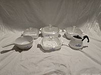 Full set of cookware pieces arranged, showing overall condition