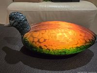 Lamp lit showing glowing amber-green glass body and metal head