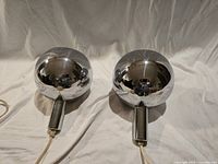 Two chrome spherical pendant lights side by side