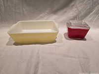 Yellow baking dish and red refrigerator dish side by side