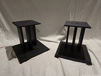 Both black wooden speaker stands side by side showing overall design
