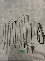 All 11 costume chain necklaces laid out flat on a surface, showing variety in styles and pendants.