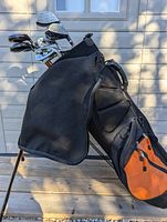 Photo of the golf bag standing upright showing black and orange color scheme.