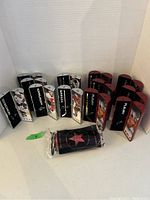 Photo showing 2007 and 2008 NHL Star Sticks cases. There are black and red cases; some contain hockey sticks, some are empty. One sealed item in a bag is included in the front.